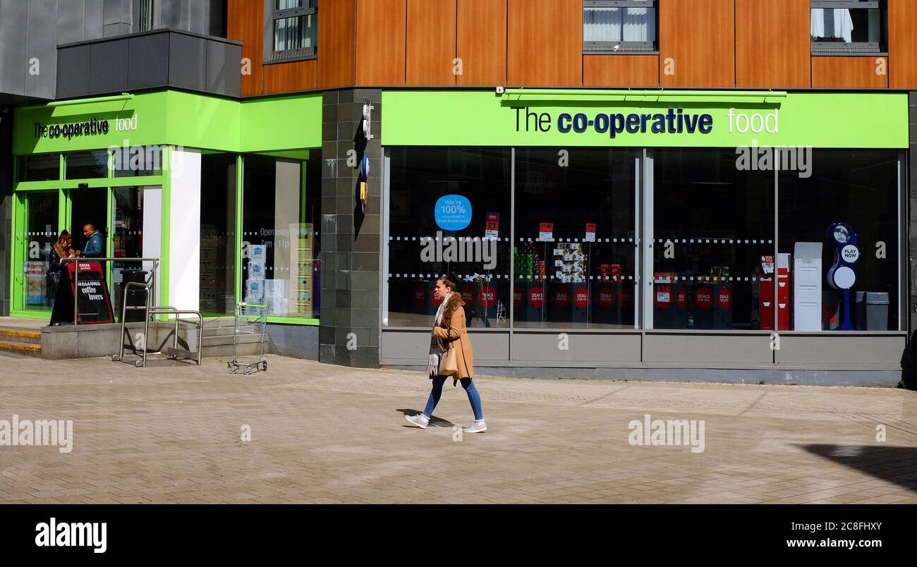 REDHILL, UNITED KINGDOM - Apr 05, 2018: A woman walks past a branch of food retailer Co-operative (Co-op) Food, which is a network operated by over 15 Stock Photo