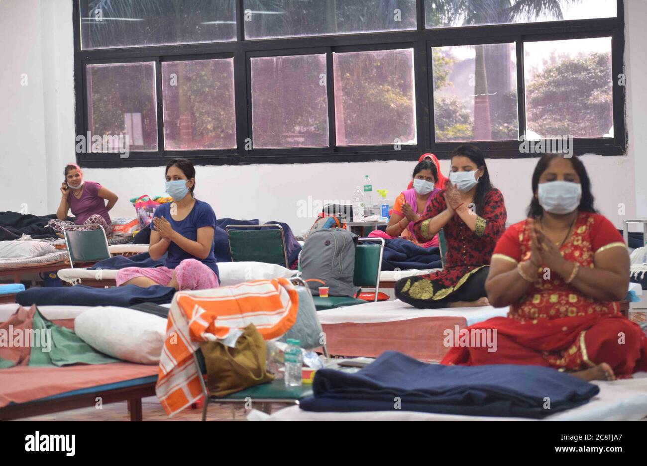 Patients suffering from coronavirus infection attend a yoga class inside a ward at the Commonwealth Games Village sports complex COVID centre in New Delhi, India on Friday July 24, 2020. Doctors For You, a not-for-profit organisation, supported the Delhi government in setting up the facility which has a capacity of 500 beds. Photograph: Sondeep Shankar Stock Photo