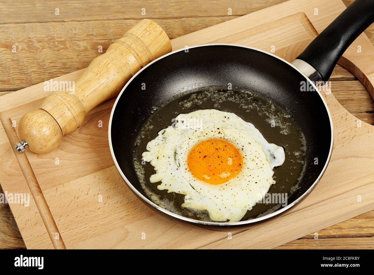 fried egg with pepper in frying pan Stock Photo
