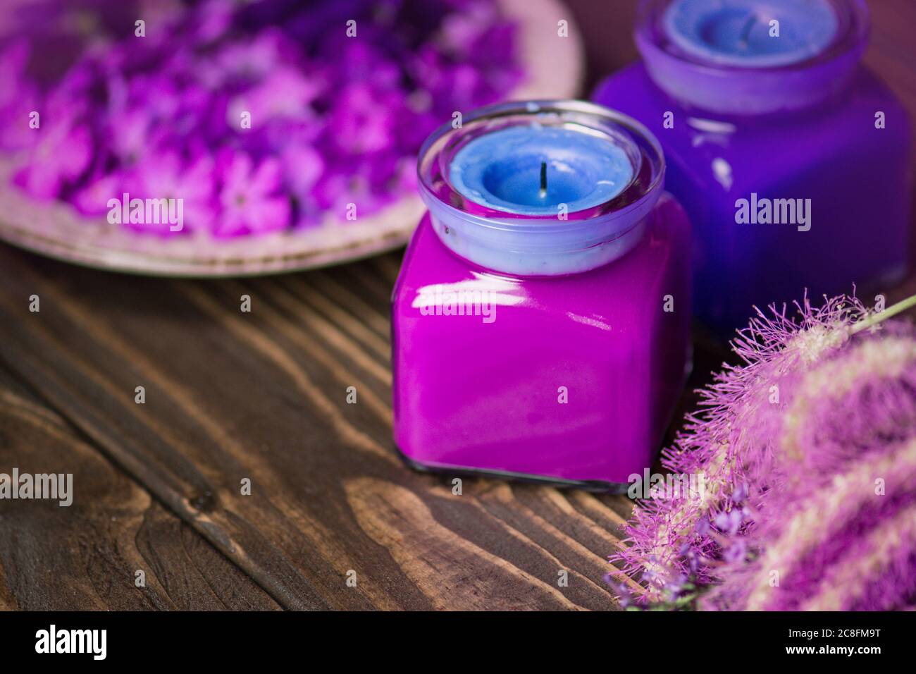 Violet and blue candles on a wooden background Stock Photo