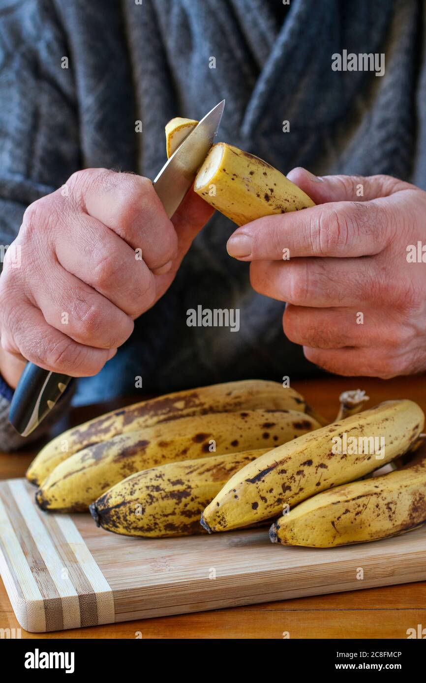 A man is peeling a banana. Healthy food Stock Photo