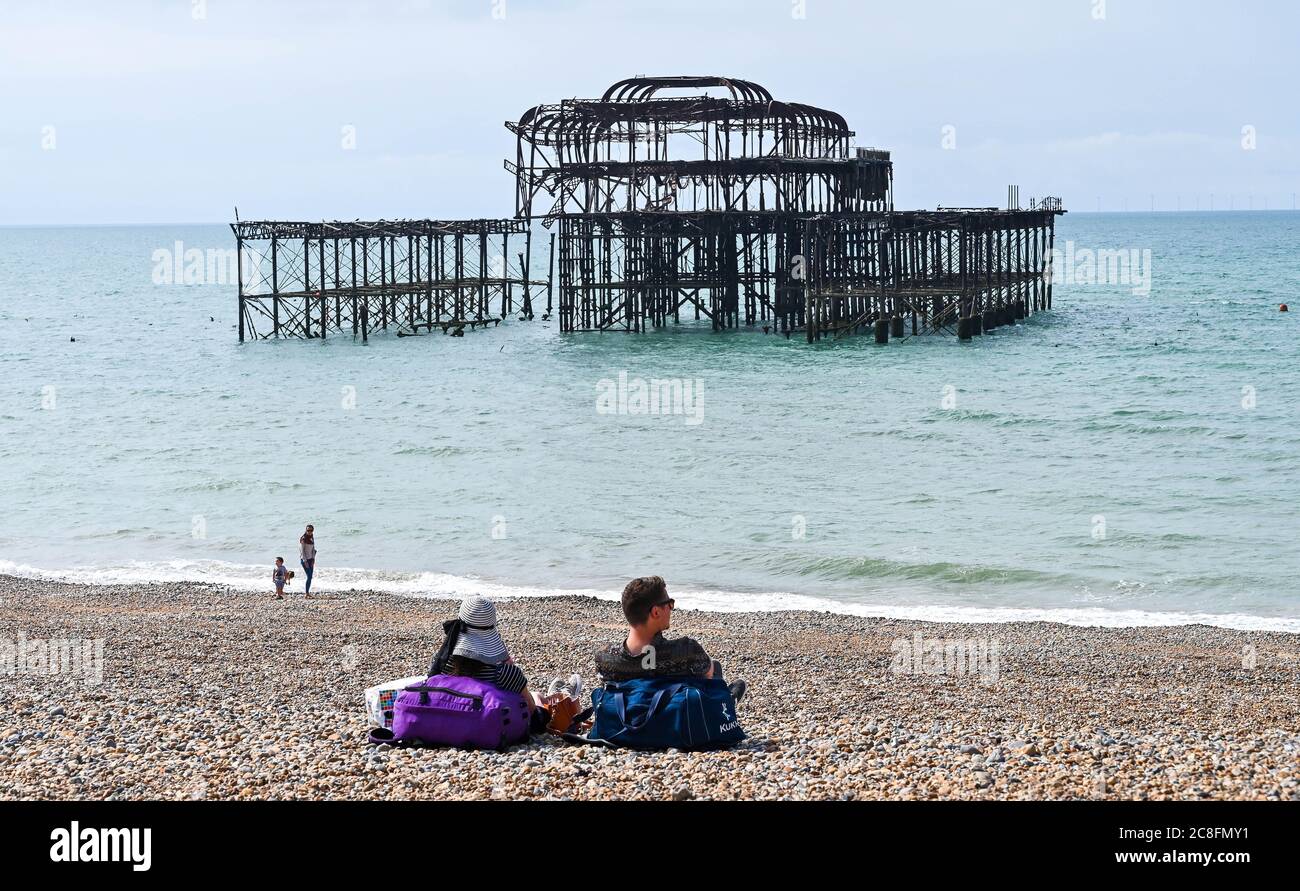 Brighton UK 24th July 2020 - Visitors enjoy a hot sunny day on Brighton beach with temperatures forecast to reach 25 degrees in some parts of the South East today  : Credit Simon Dack / Alamy Live News Stock Photo