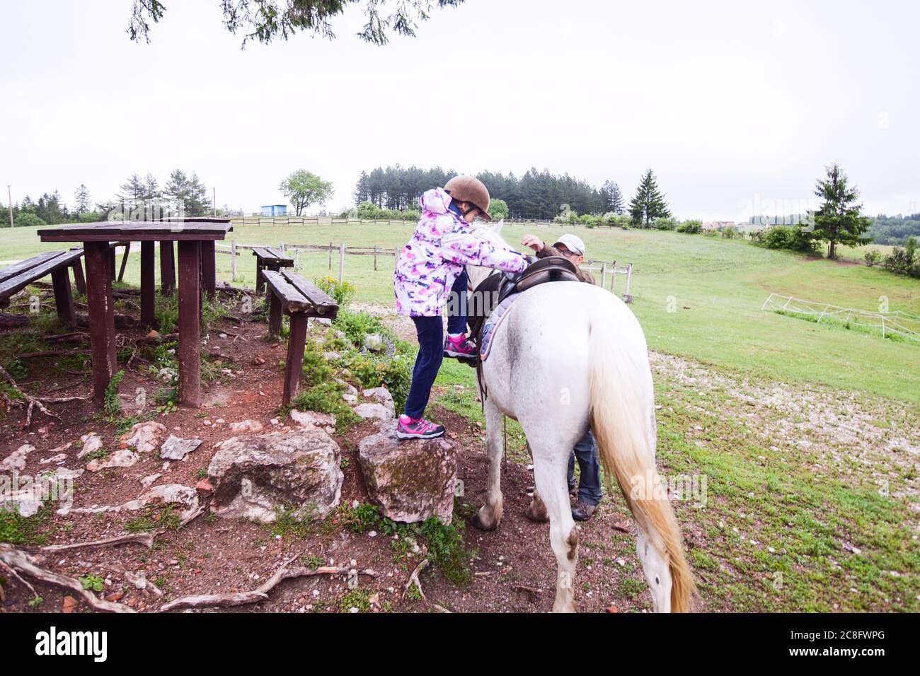 Horseback riding lesson- little girl getting a horse at ranch , country landscape Stock Photo