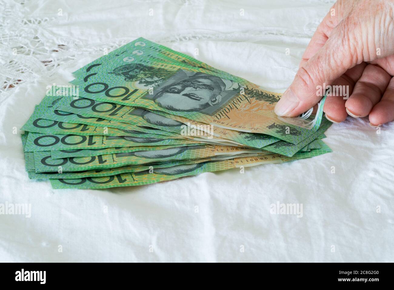 Person placing and counting money, one hundred dollar notes, Australian currency Stock Photo