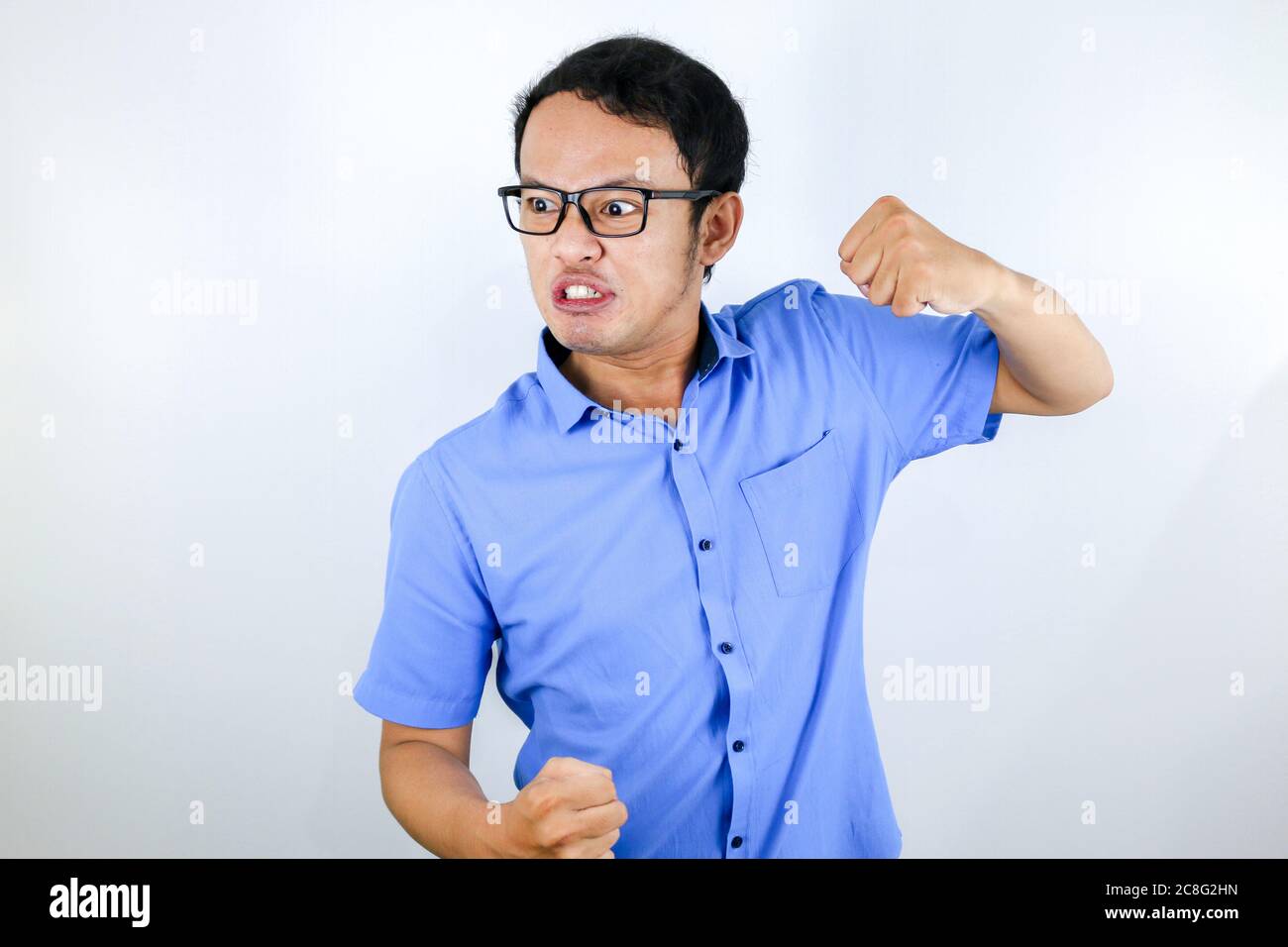 Young Asian Man wear blue shirt is funny angry face with shouting and ...