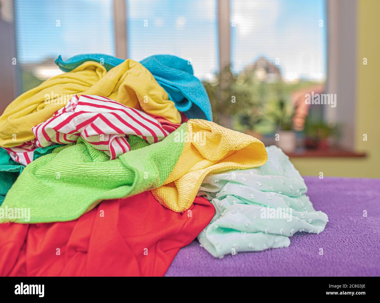 Stack of laundry for ironing on an ironing board Stock Photo Alamy