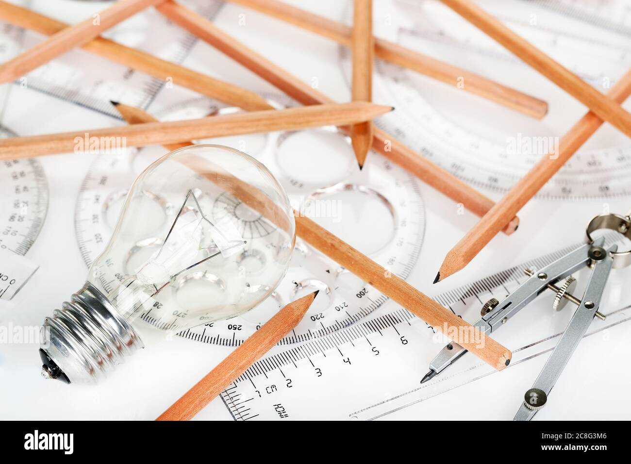 light bulb with rulers and pencils on desk, idea concept Stock Photo ...