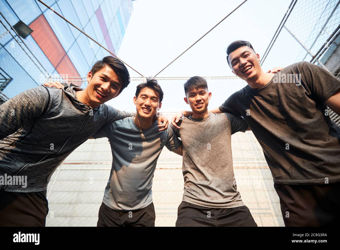 portrait of a team of young asian athletes looking down at camera smiling Stock Photo