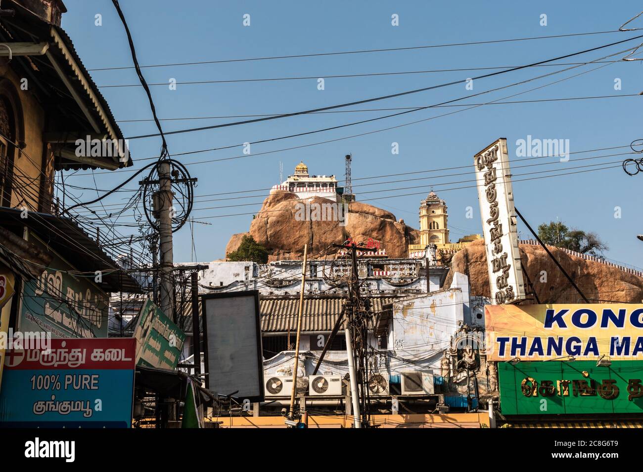 Trichy, Tamil Nadu, India - February 2020: The ancient Rock Fort temple on a rocky outcrop towering over a market in the city of Tiruchirappalli. Stock Photo