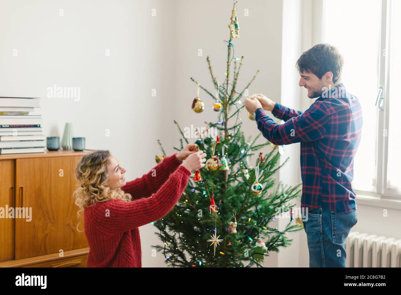 Couple decorating Christmas tree at home Stock Photo