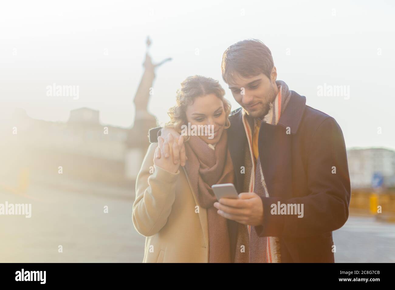 Couple using smartphone on street, Firenze, Toscana, Italy Stock Photo
