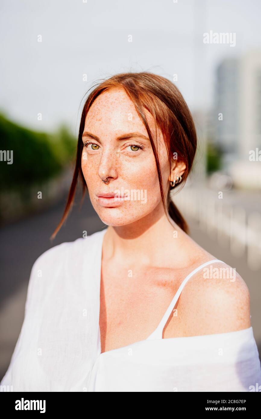 Portrait of woman with long red hair, looking at camera Stock Photo - Alamy