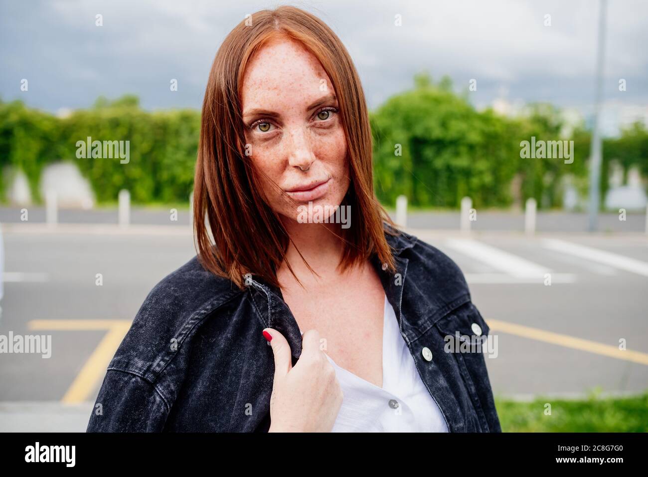 Portrait of woman with long red hair, looking at camera Stock Photo - Alamy