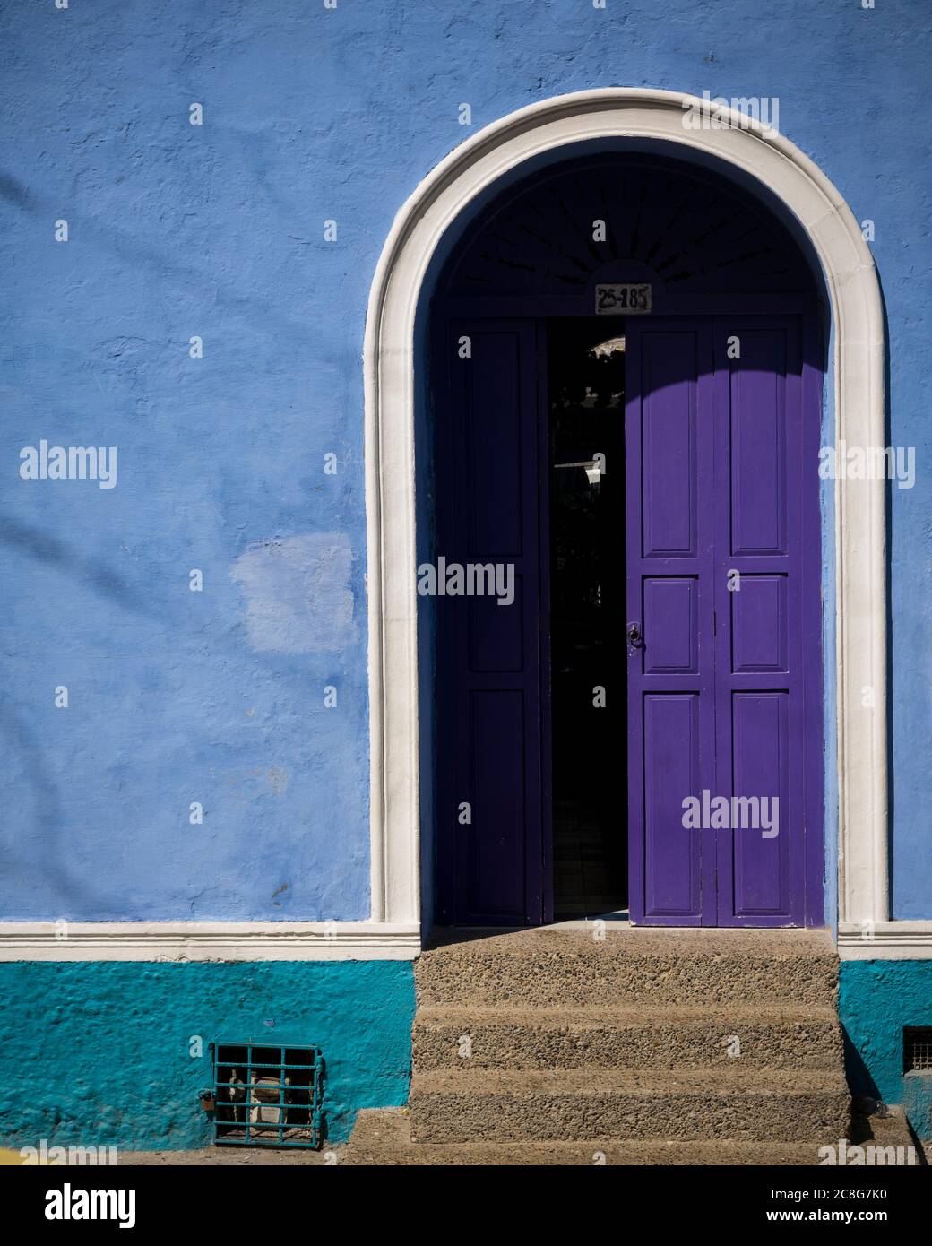 Colourful blue wall and purple painted front door in the Old City, Cartagena Stock Photo