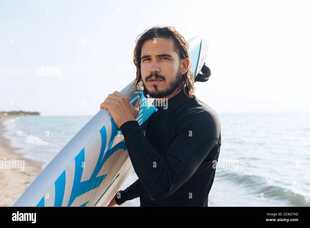 Surfer with surfboard by seaside Stock Photo