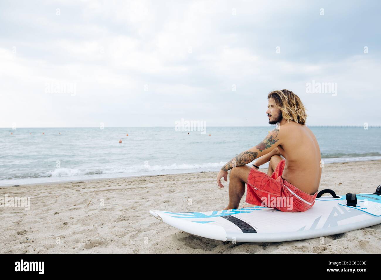 Surfer with surfboard by seaside Stock Photo