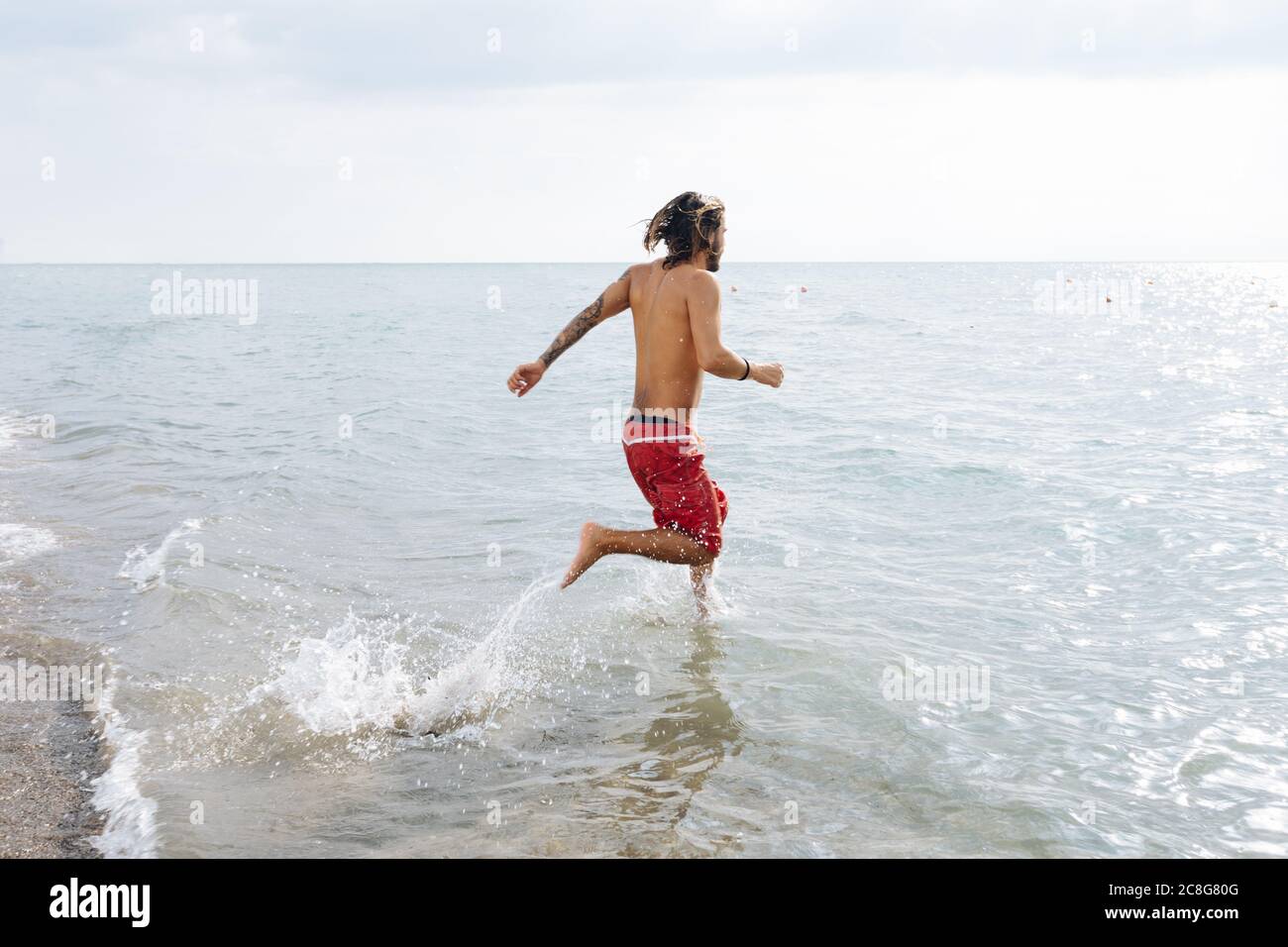 Man running into sea Stock Photo