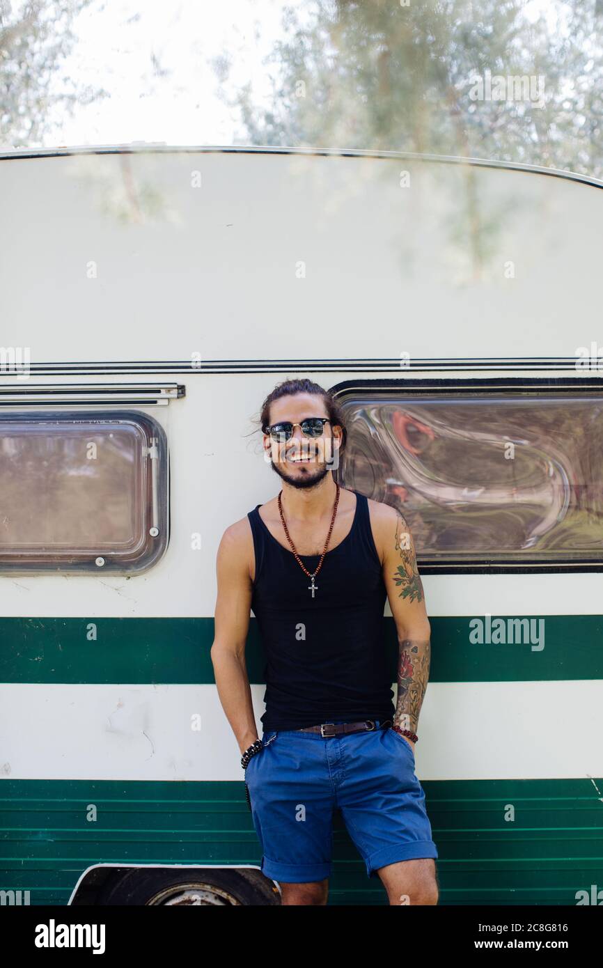 Man leaning against caravan Stock Photo