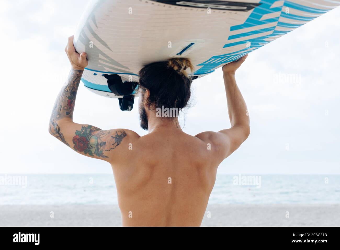Surfer with surfboard by seaside Stock Photo