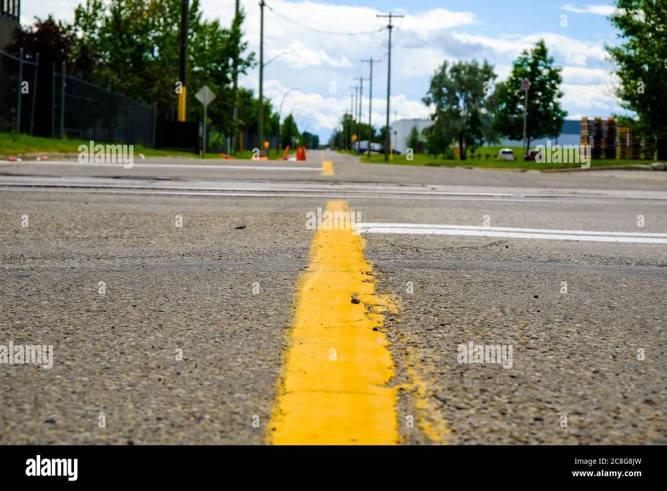 Yellow dividing line on a street in city - Low Angle Stock Photo
