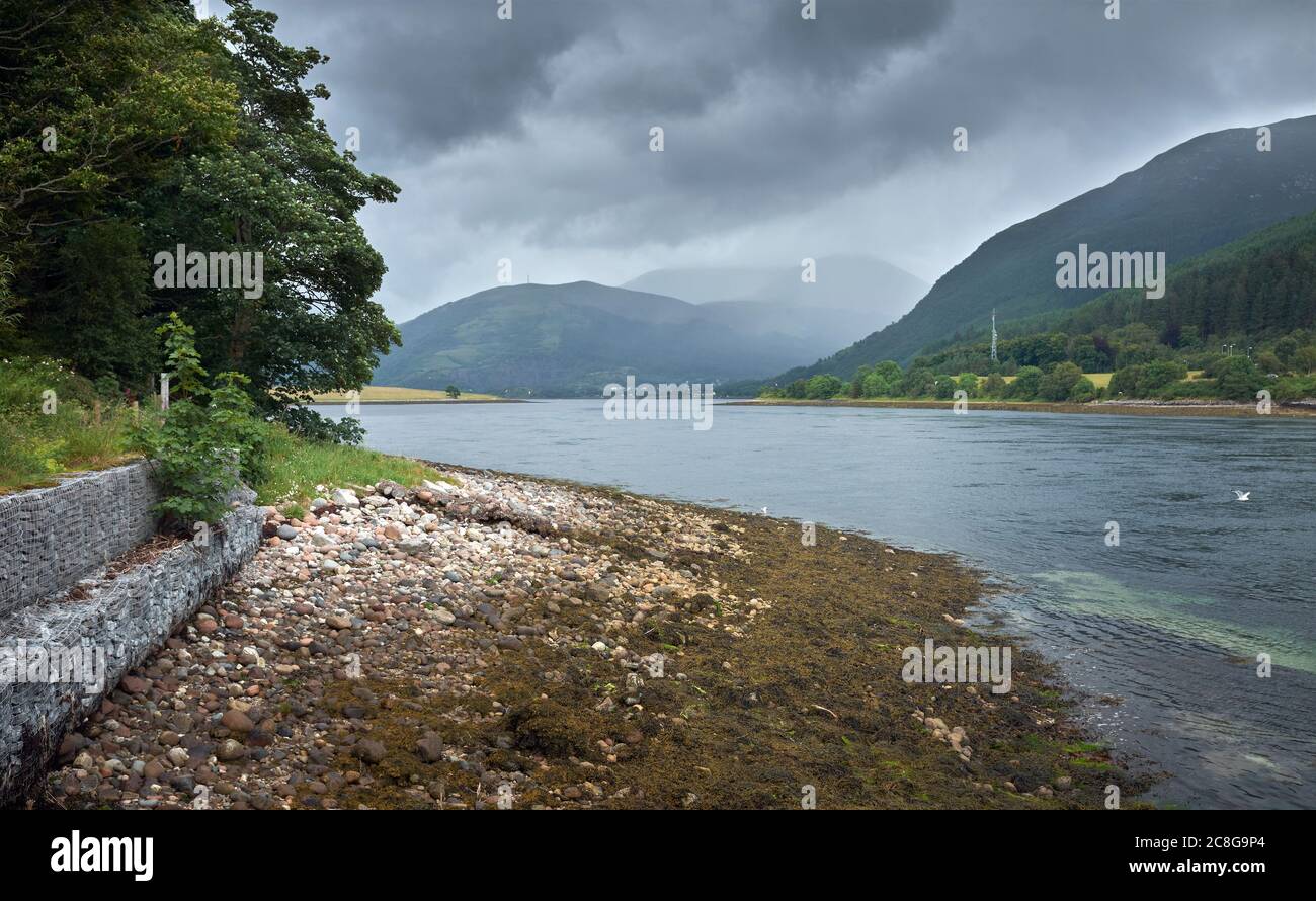From the old ferry quay at North Ballachilish looking south east across overcast skies above sea water Loch Leven to Ballachulish Stock Photo