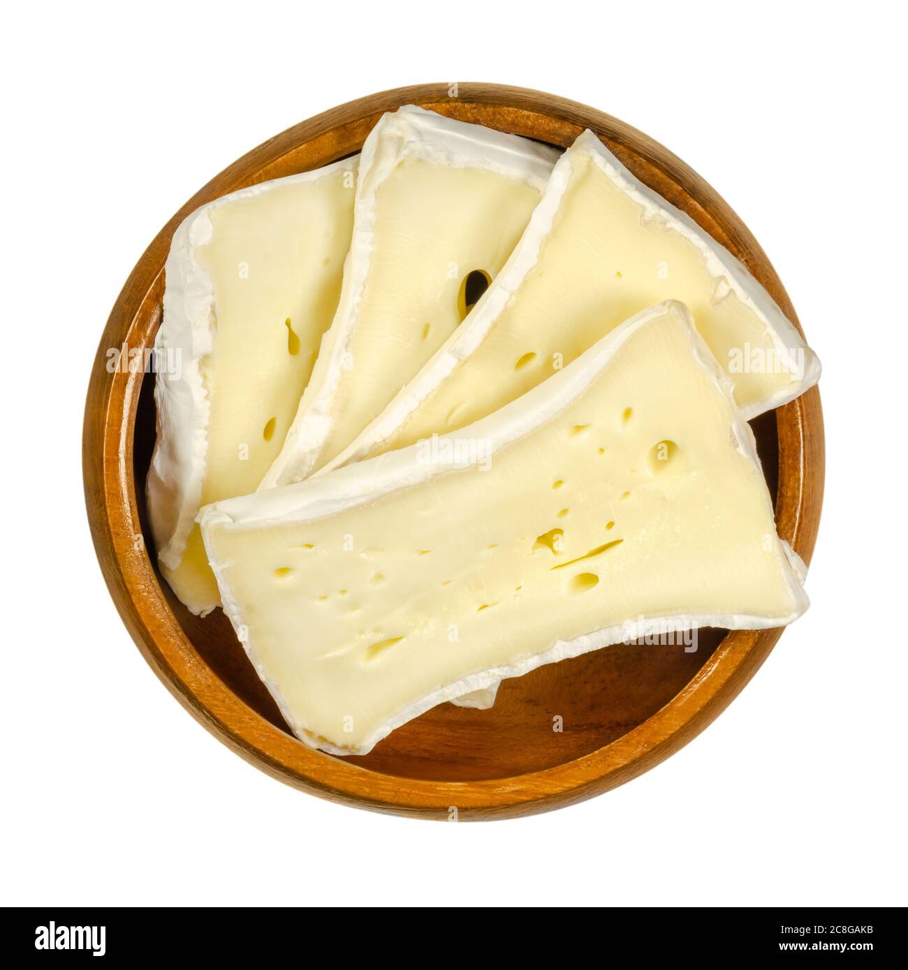 Slices of soft mould cheese in wooden bowl. Moist creamy cheese, made of cow milk, ripened on the surface with a special fungus. Camembert or Brie. Stock Photo