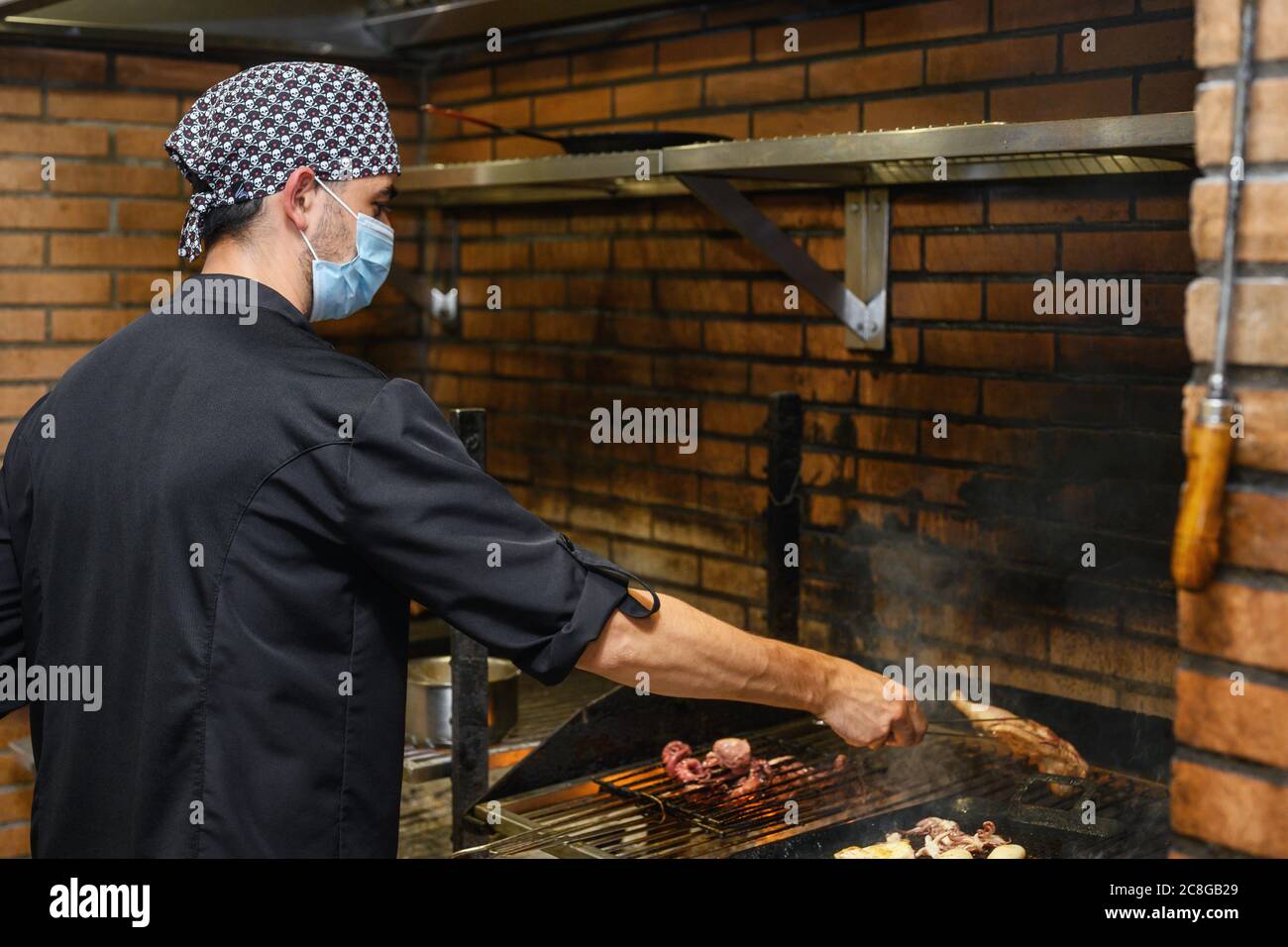 Chef grilling steaks in commercial kitchen. High quality photo Stock Photo