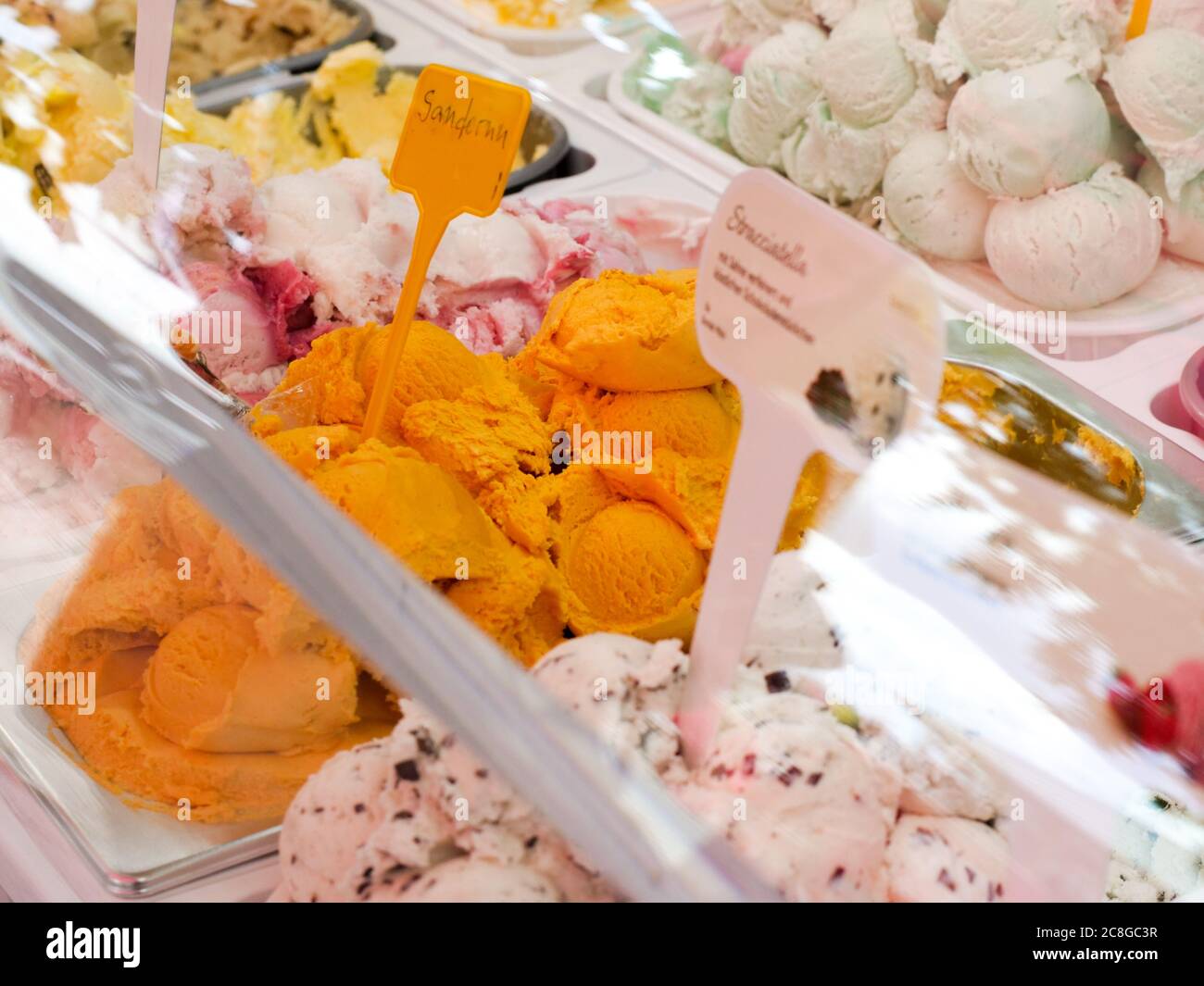 italienisches Speiseeis Eis in einer Kühltheke einer Eisdiele Café Eiscafé verschiedene Sorten Sanddorn Stracciatella Joghurt Walnuss Auswahl Eiscreme Stock Photo