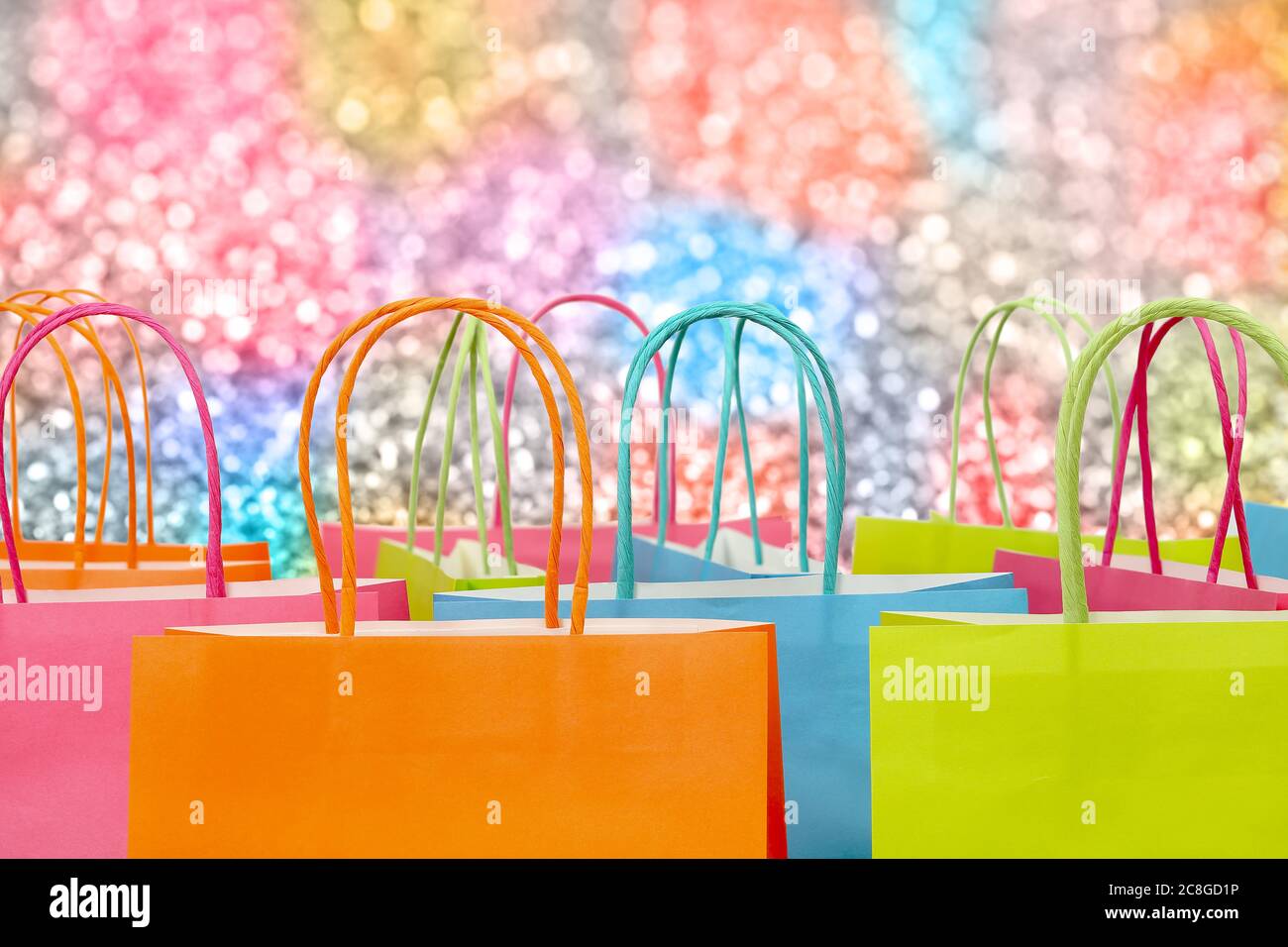 colorful paper shopping bags against glitter background Stock Photo - Alamy