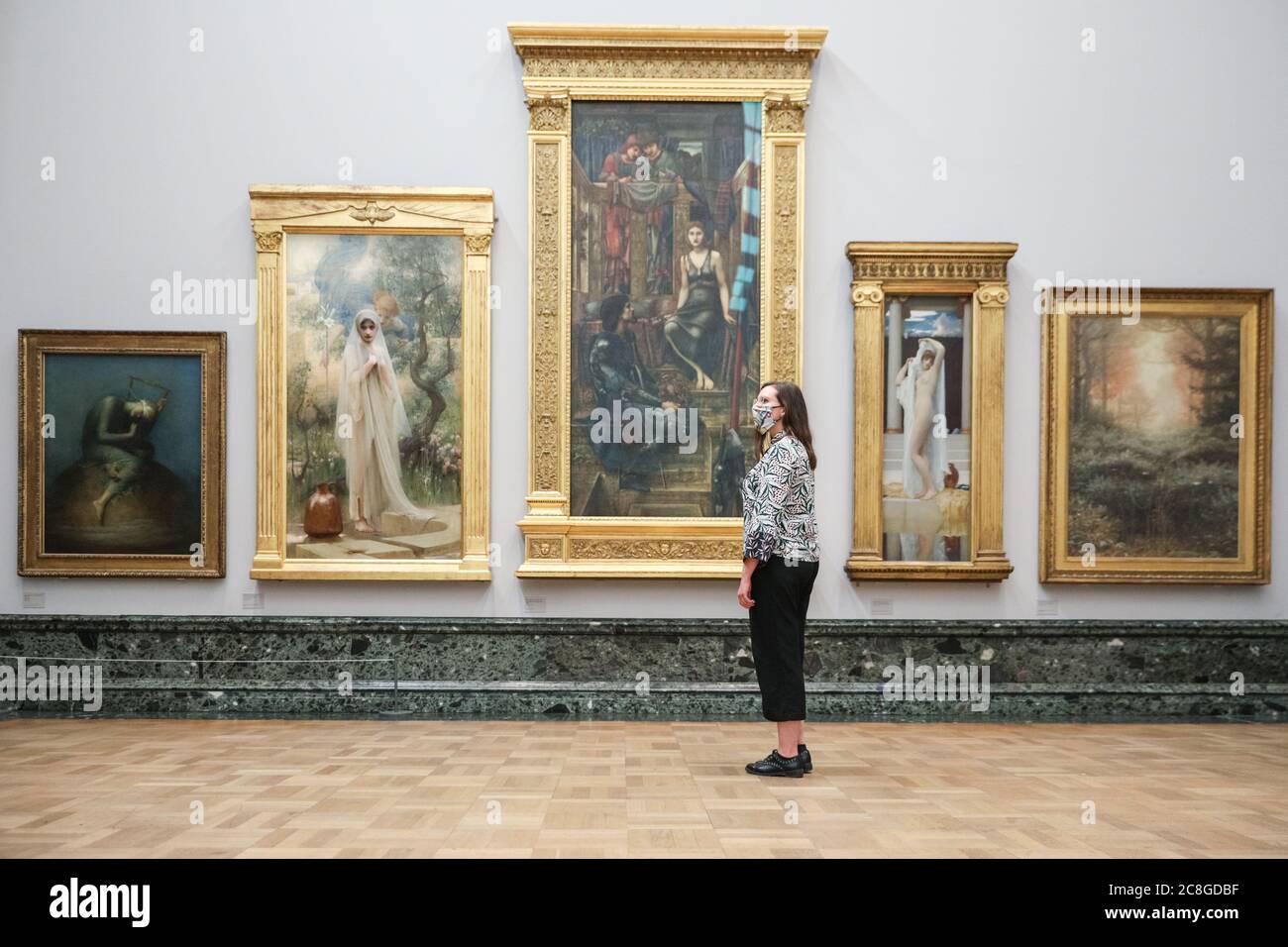 London, UK. 24th July, 2020. An assistant looks at various works in the Pre-Raphaelite collection. Tate Britain, along with other Tate Galleries in the country will re-open to visitors from Monday, 27th July with social distancing measures in place. Credit: Imageplotter/Alamy Live News Stock Photo