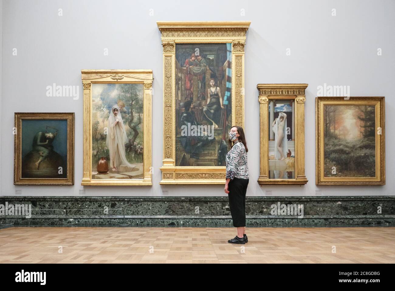 London, UK. 24th July, 2020. An assistant looks at various works in the Pre-Raphaelite collection. Tate Britain, along with other Tate Galleries in the country will re-open to visitors from Monday, 27th July with social distancing measures in place. Credit: Imageplotter/Alamy Live News Stock Photo
