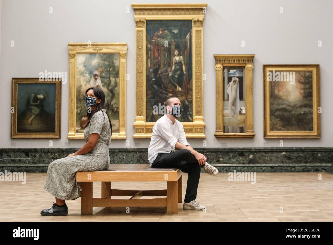 London, UK. 24th July, 2020. Two assistants sit in the Pre-Raphaelite room. Tate Britain, along with other Tate Galleries in the country will re-open to visitors Monday, 27th July with social distancing measures in place. Credit: Imageplotter/Alamy Live News Stock Photo