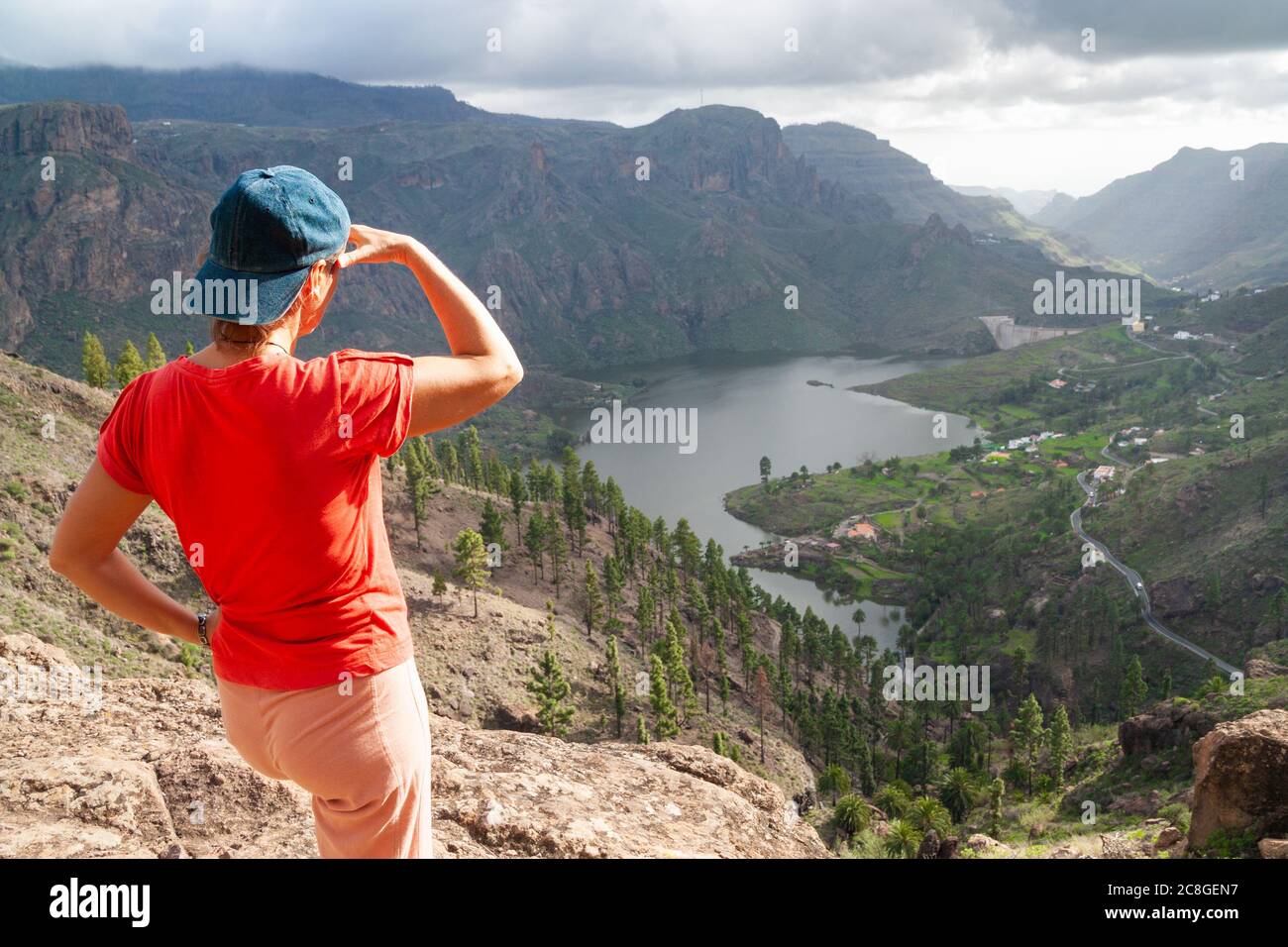 Female hiker looking over presa (reservoir) at Soria on Gran Canaria, Canary Islands, Spain Stock Photo