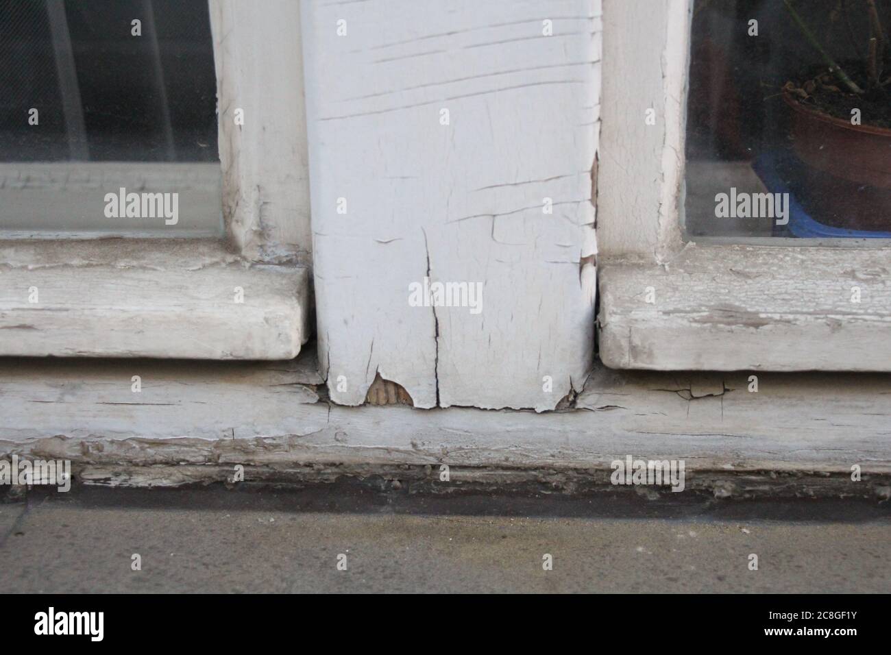 The old wooden window frame and window sill, painted white, are in a