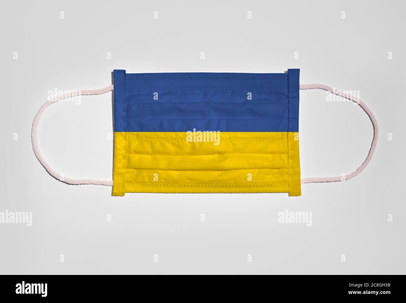 Symbolic picture Corona crisis, face mask, breathing mask, mouth and nose protection with flag of Ukraine, white background Stock Photo