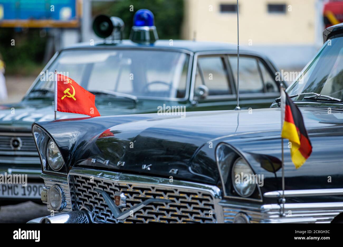 Beuster, Germany. 24th July, 2020. The flags of the Soviet Union and the GDR are waving on a Soviet Chaika limousine which is on display at the Blue Light Days in the Blue Light Museum Beuster. Despite corona protection measures, the blue light museum on the Elbe celebrates its museum week. The collection of historical fire brigade, police and military technology has been open to visitors since 2005. Credit: Jens Büttner/dpa-Zentralbild/ZB/dpa/Alamy Live News Stock Photo