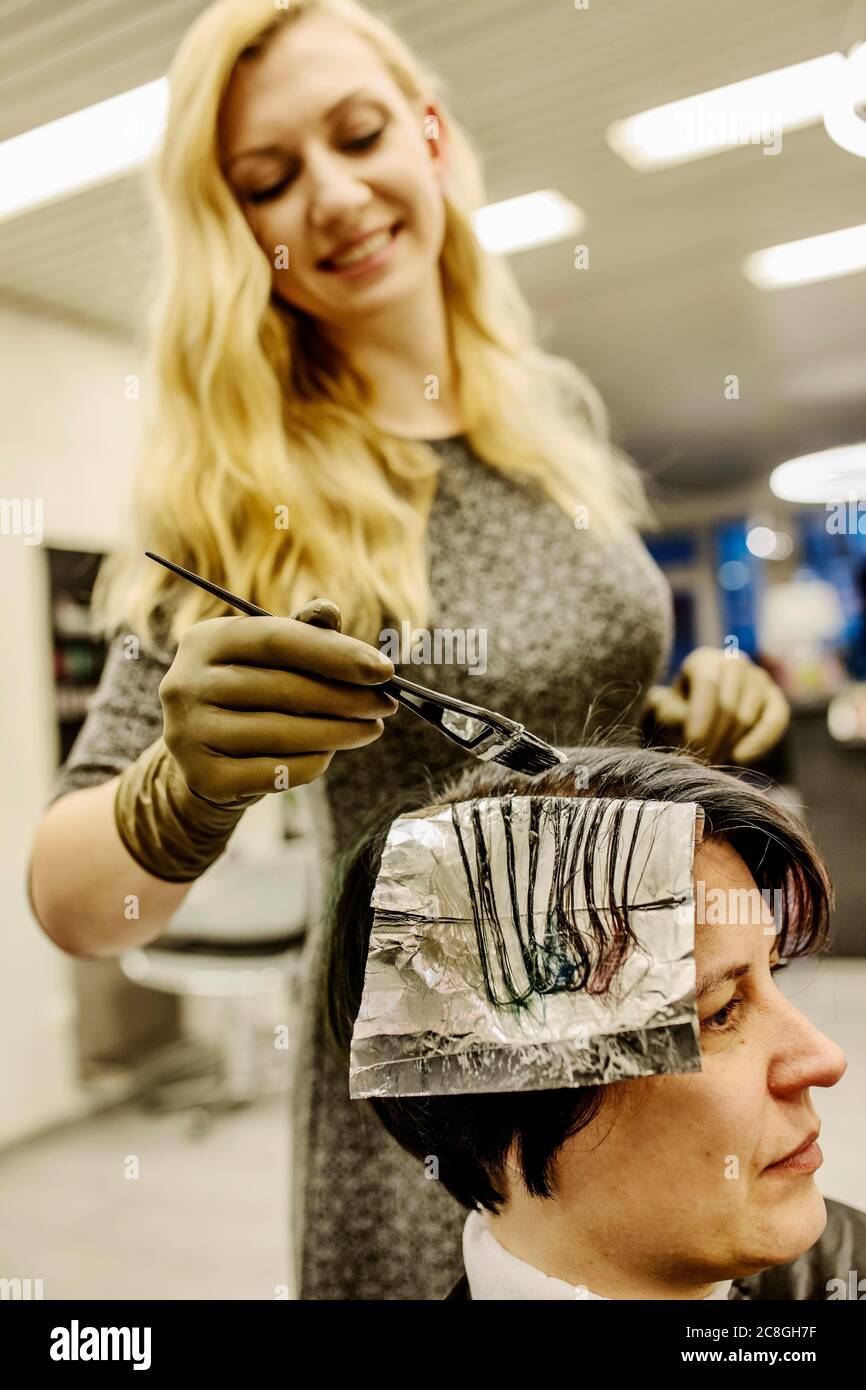 https://c8.alamy.com/comp/2C8GH7F/hairdresser-in-a-hairdressing-salon-dying-strands-of-hair-with-aluminium-foil-north-rhine-westphalia-germany-2C8GH7F.jpg