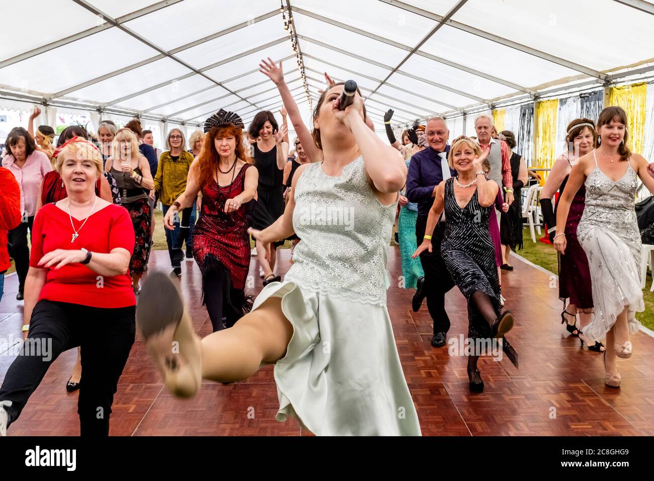Women Dressed In Period Costume Dancing At The Great Gatsby Fair, Bexhill on Sea, East Sussex, UK Stock Photo