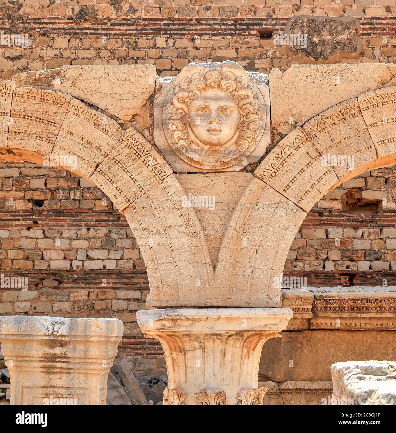 Columned arch with a Medusa head, ruined city of Leptis Magna, Libya Stock Photo