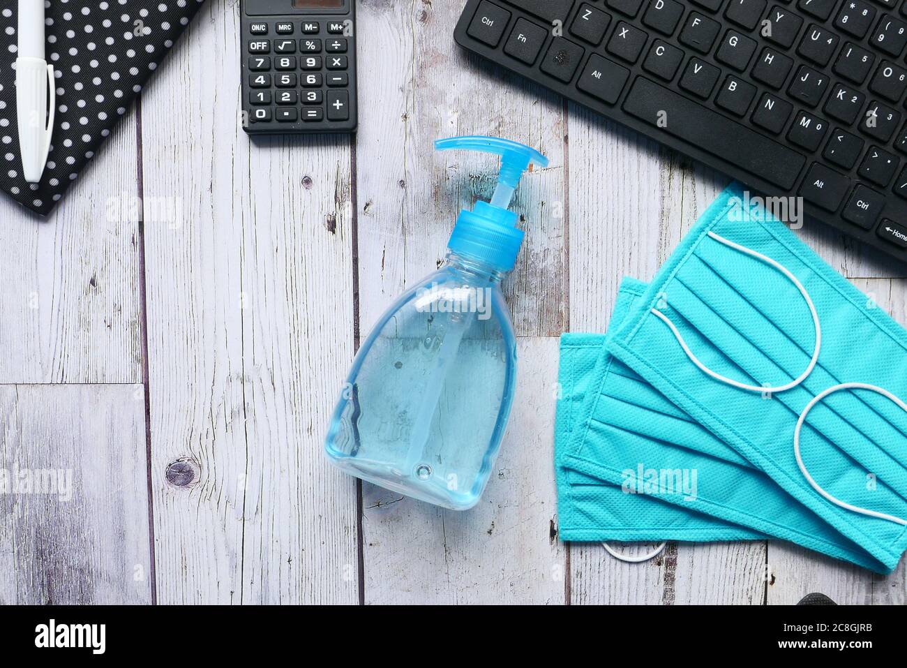 Surgical masks, and hand sanitizer on office desk Stock Photo - Alamy