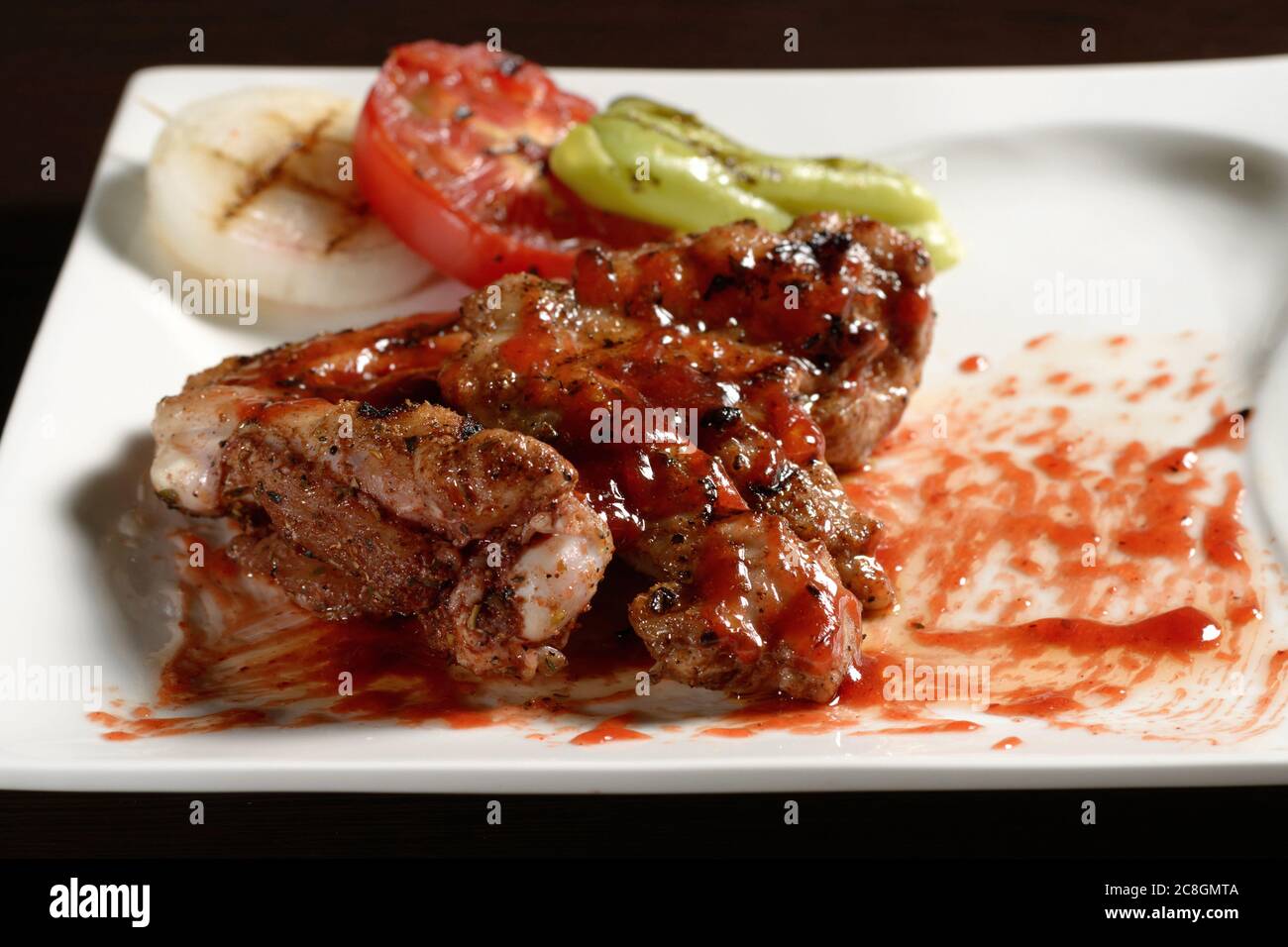 Roasted chicken wings close up with grilled vegetables. Photos for