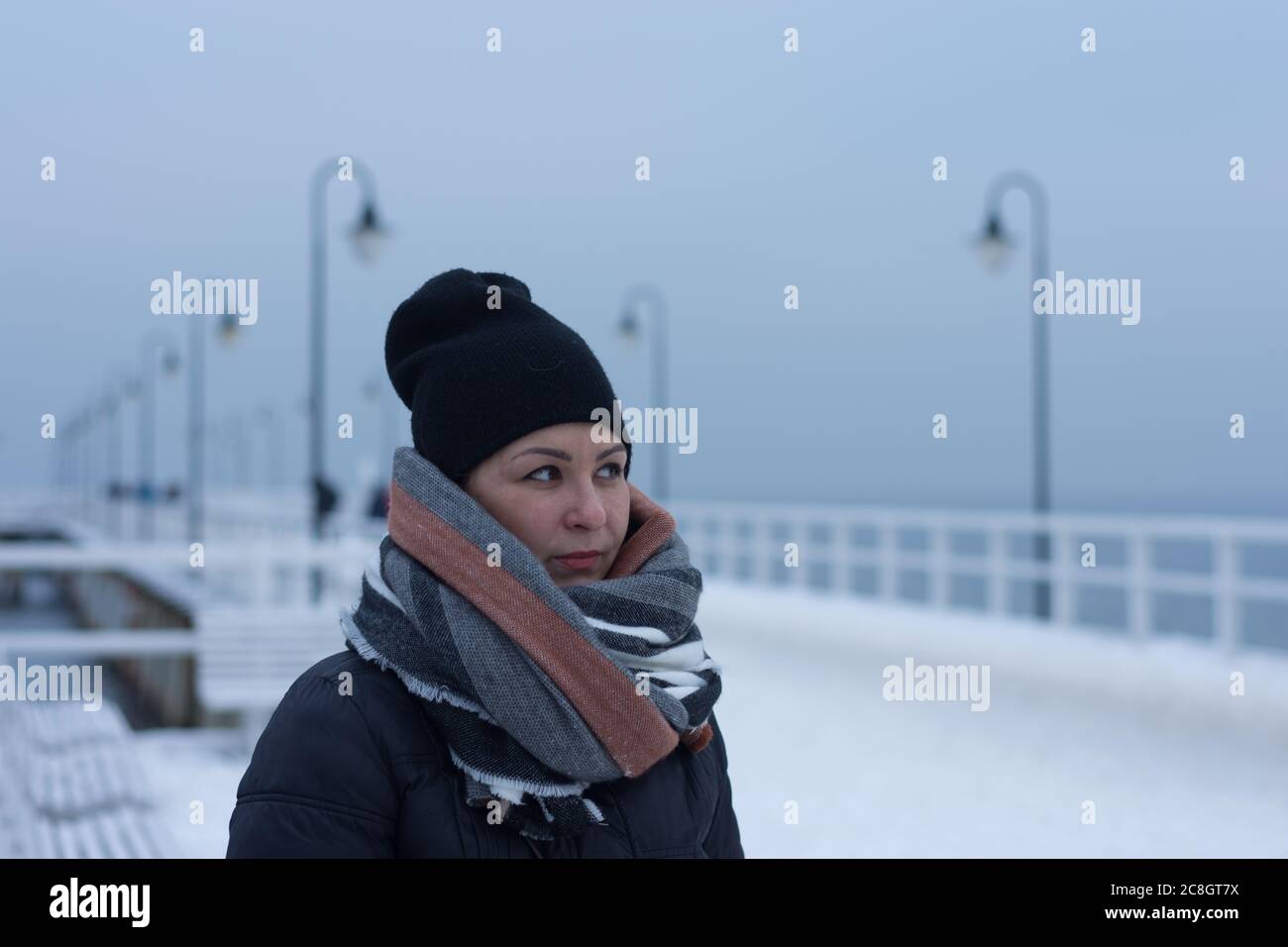 Winter portrait of young woman dressed warm for freezing winter conditions by Baltic Sea in Northern Europe Stock Photo