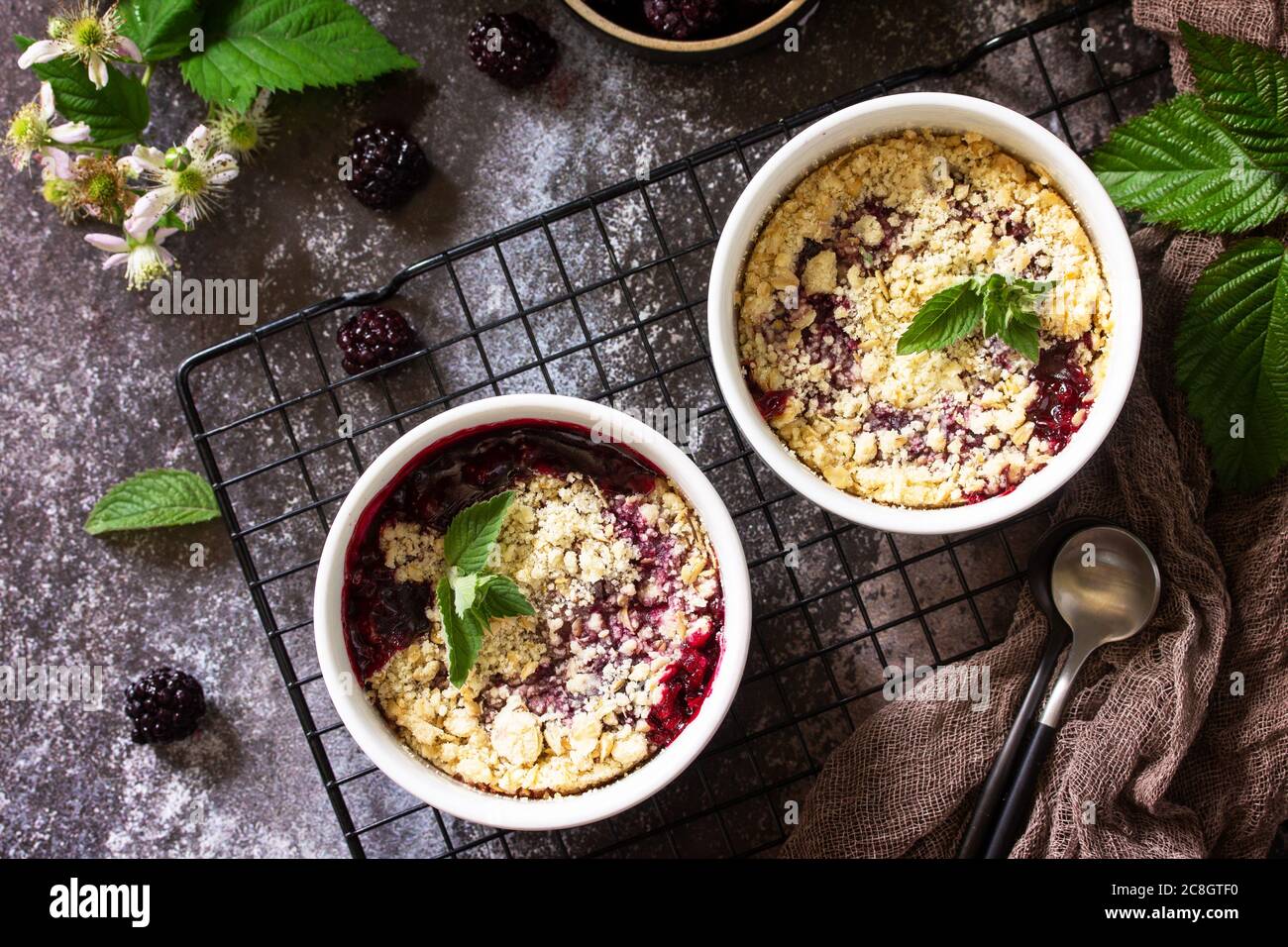 Homemade summer dessert. Blackberry crumble in baking dish on a stone