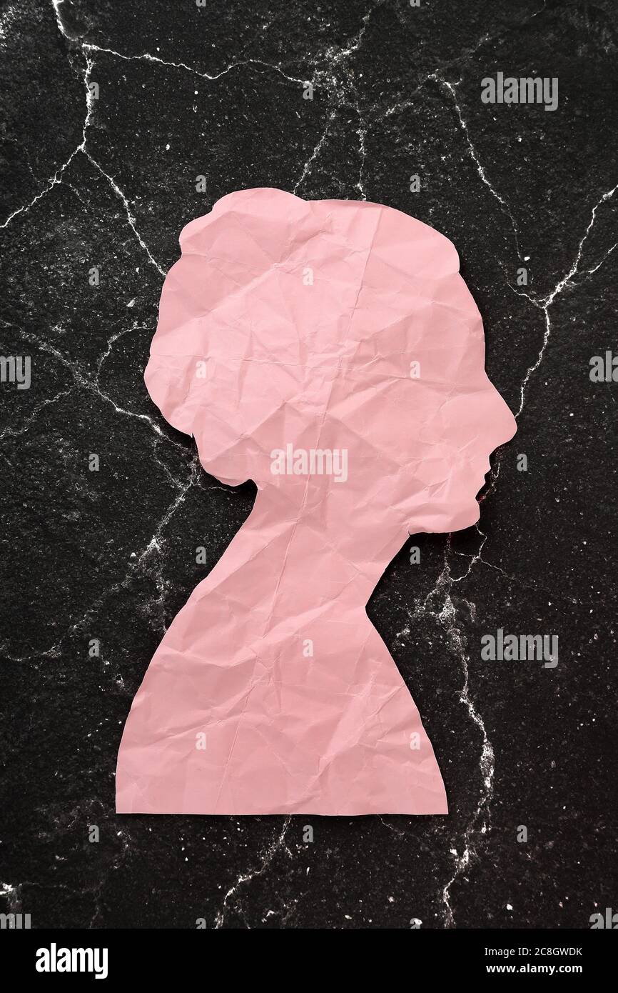 crumpled paper head on cracked black background, abstract concept Stock Photo
