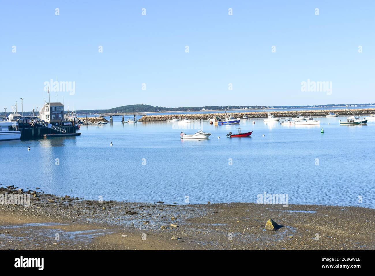Plymouth, MA USA harbor with boats,buoys, stone breakwater, foot bridge