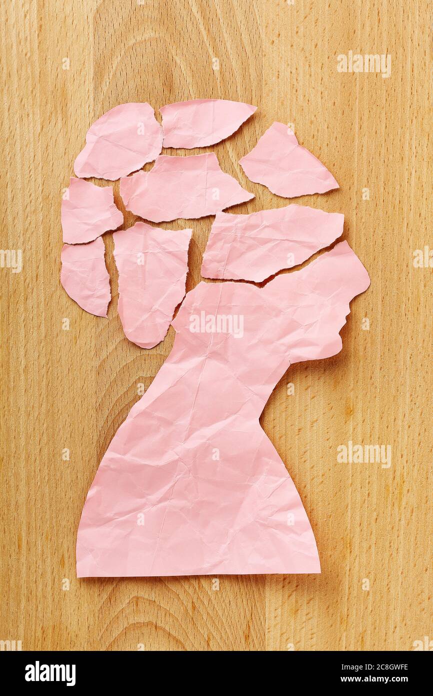 torn and crumpled female paper head on wood, abstract concept Stock Photo