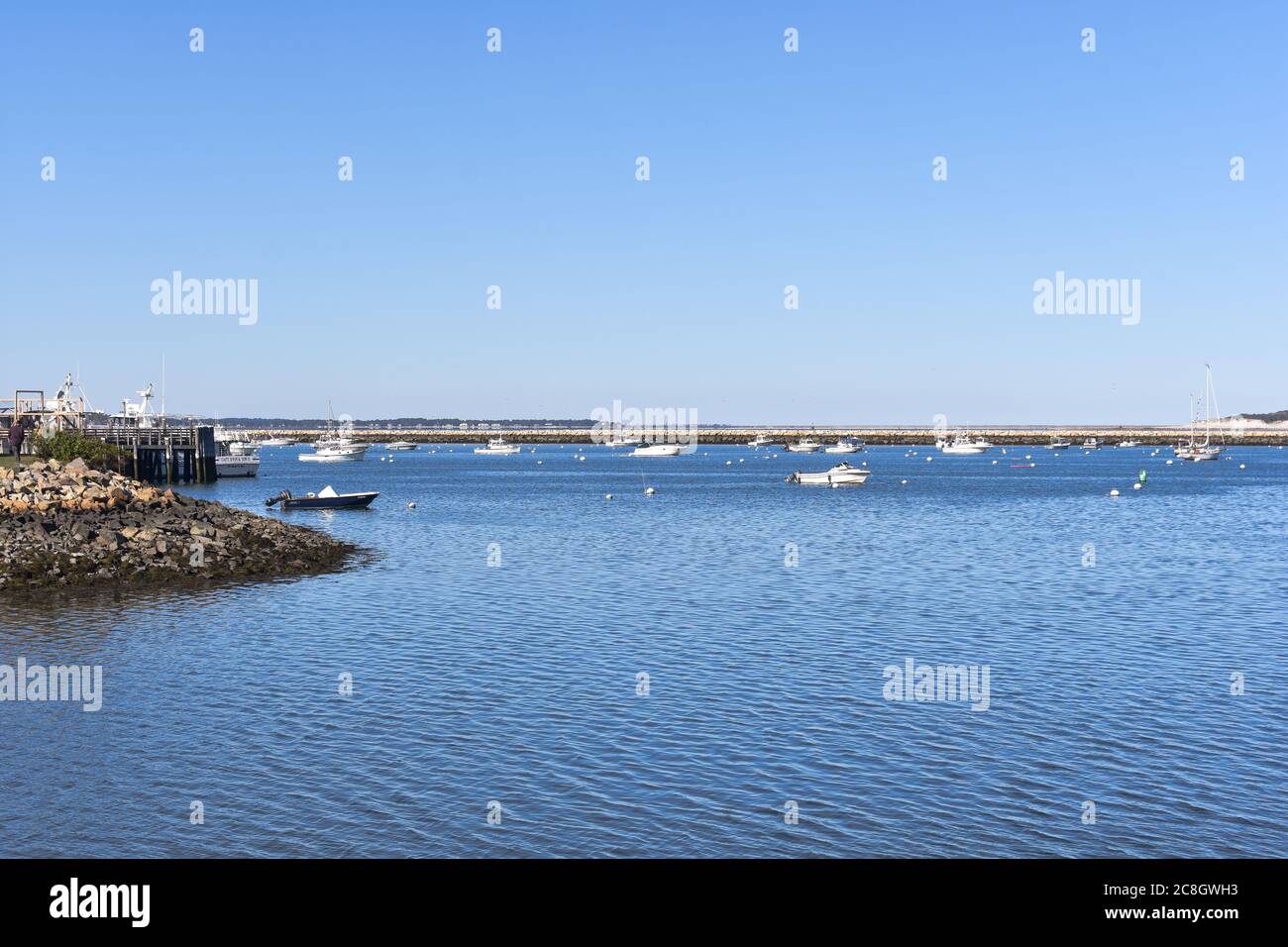 Plymouth, MA harbor with boats and buoys, dock and stone jetty with