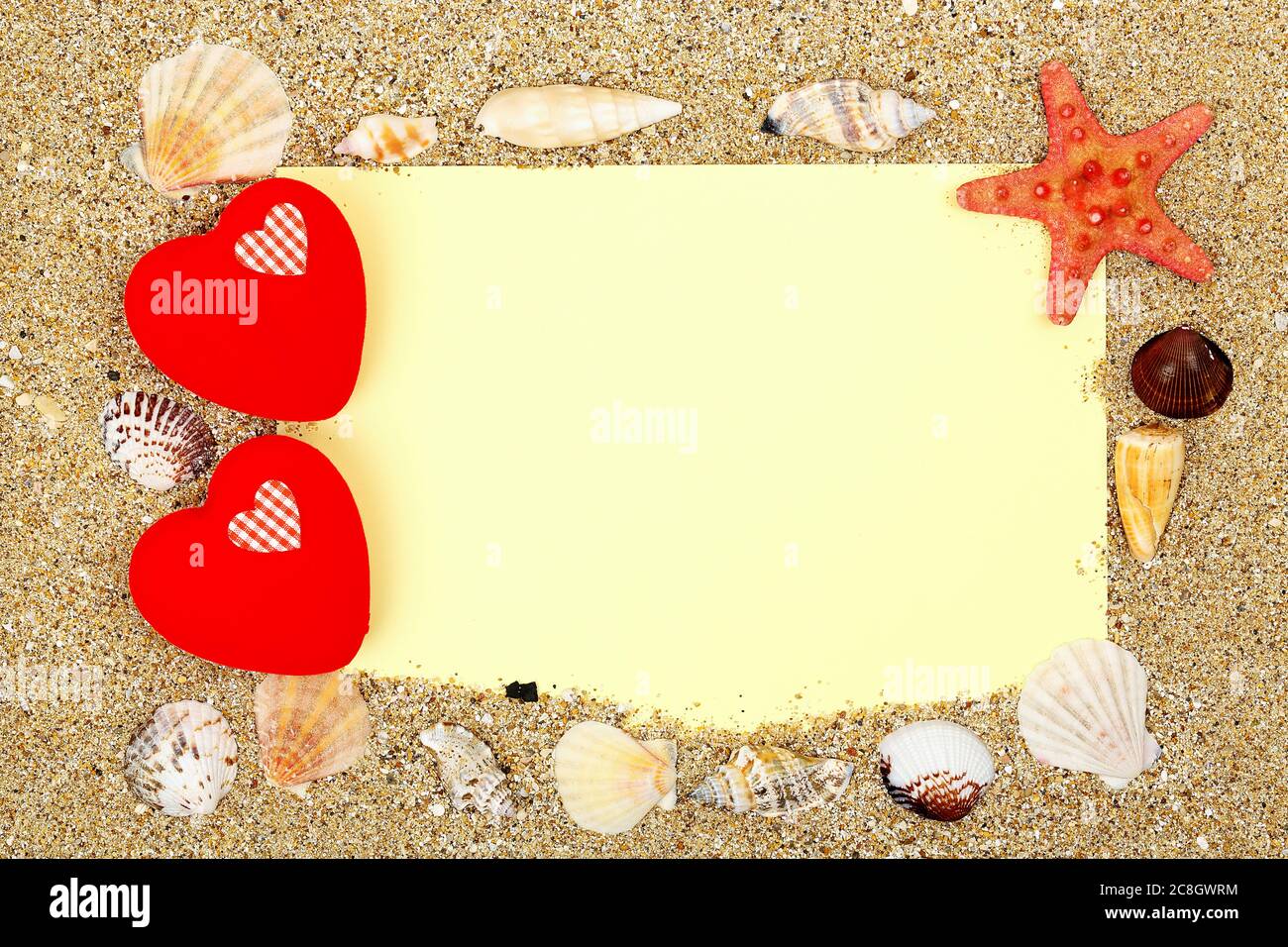 blank paper with love hearts and seashells on sand, love background Stock Photo