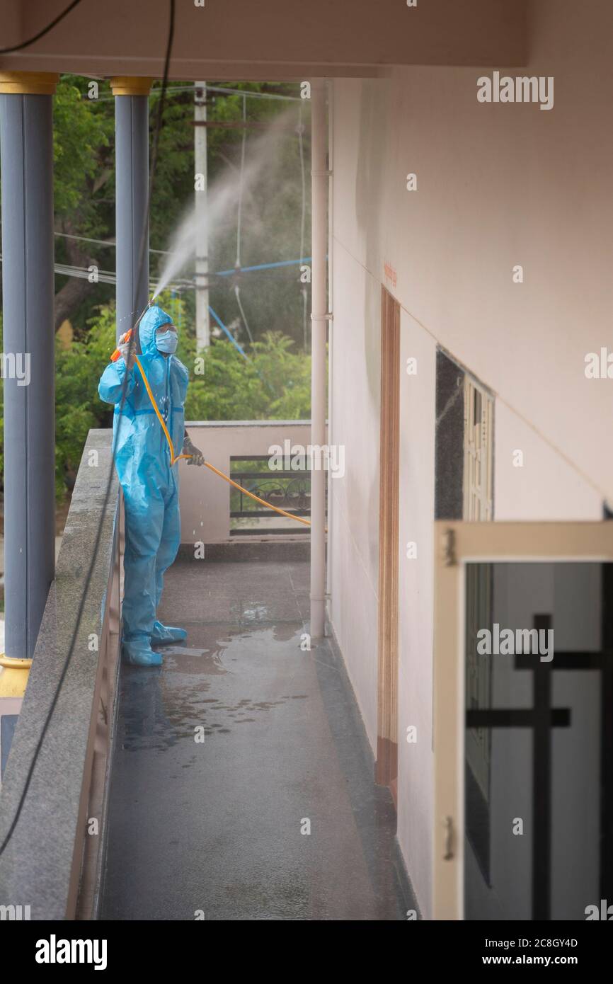 Maski, India : 24, July 2020 : Frontline worker sanitizing or Disinfecting home or residential building due to covid-19 or coronavirus outbreak by Stock Photo