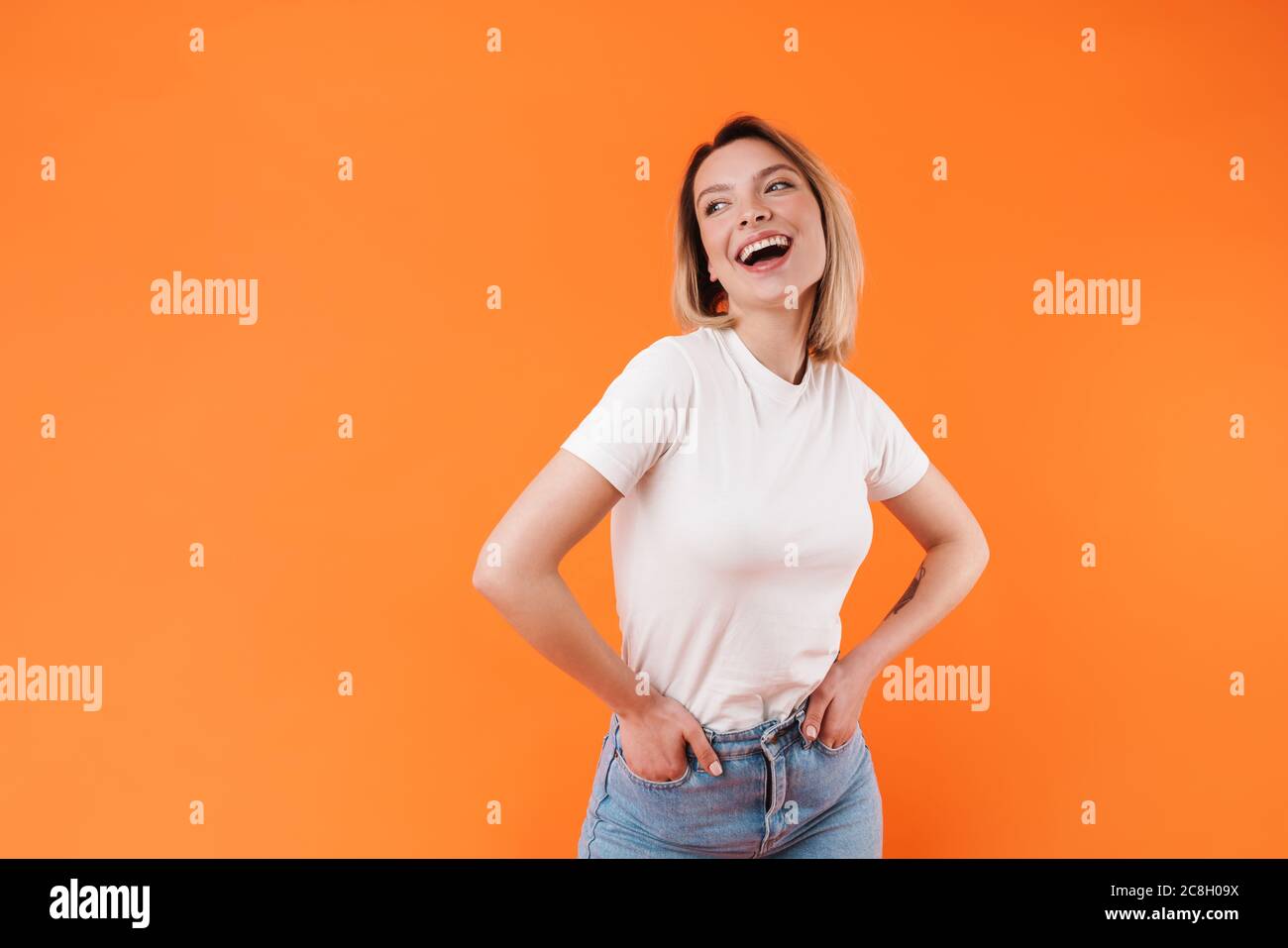 Image of joyful pretty woman laughing and posing with hands in pockets ...